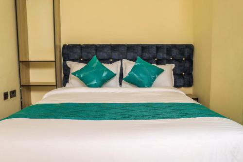 ChukaHidden Treasure Lodge Chuka的一间卧室配有一张带绿色和白色枕头的大床