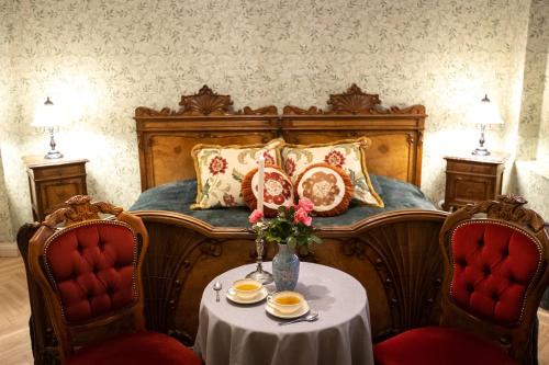 图梅Jaunmoku Palace Complex Hotel的一间卧室配有一张带桌子和两把椅子的床