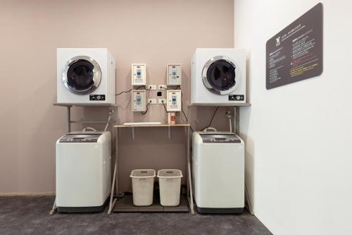 台中市奇异果快捷旅店 - 捷运中清店(逢甲2店）的一间设有两台洗衣机和一台洗衣机的房间