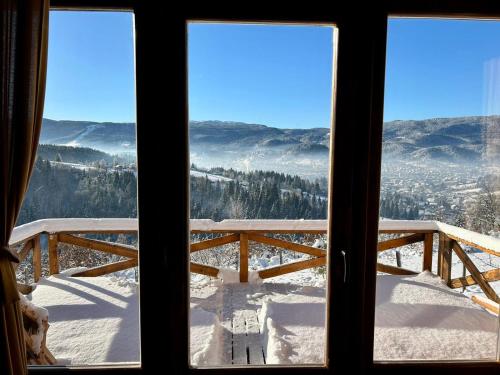 帕莱Vikendica Tromedja Pale的窗户享有雪覆盖的山景。