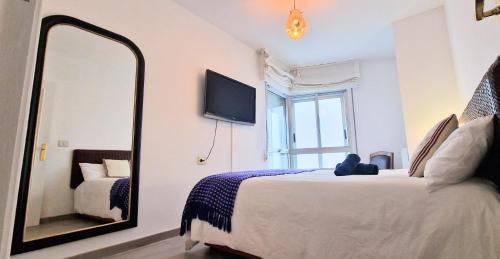 桑亨霍SANXENXO , apartamento nuevo 300 mts playa Silgar的一间卧室配有一张大床和镜子