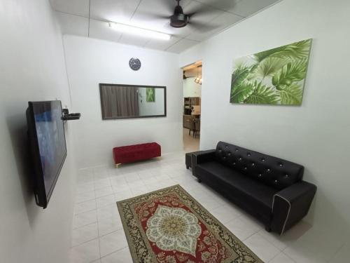 日得拉Adempuri Homestay 3的客厅配有黑色沙发和平面电视。