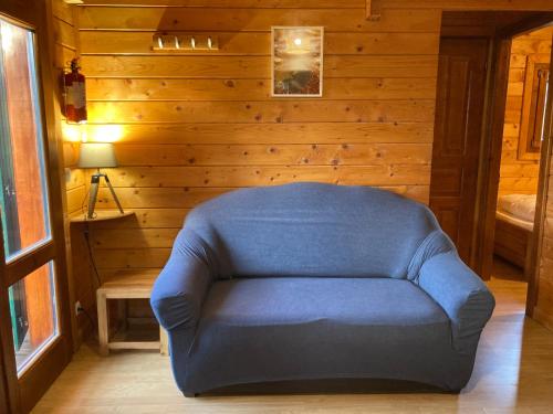 Lac des Rouges TruitesCamping-Chalets La Favière的配有木质墙壁的客房内的蓝色椅子