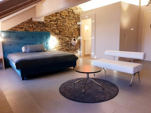 奥尔塔圣朱利奥阿拉柯利酒店的一间卧室配有一张床、一张桌子和石墙