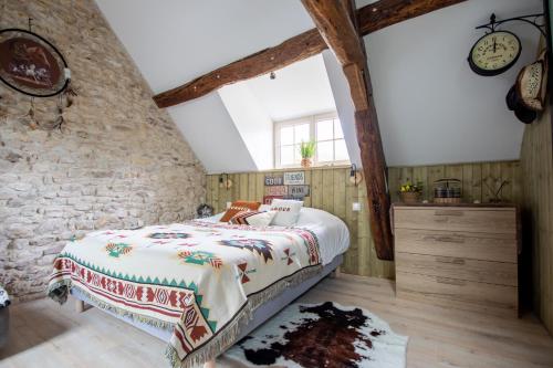 GillesLe Moulin de l'étang的一间卧室设有一张床和石墙