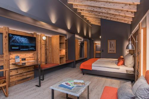 采尔马特贝斯坎普酒店的一间卧室配有一张床、一台电视和一张沙发