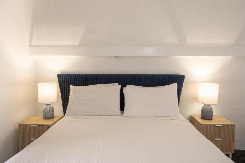 仙女港Caledonian Inn - The Stump的一间卧室配有一张带两张台灯的床铺。