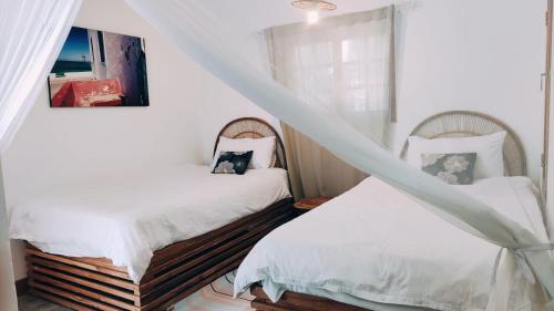 托弗海滩Hakha Beach House的一间卧室设有两张床和窗户。