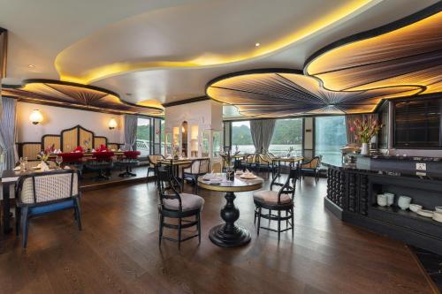 下龙湾Lotus D'Orient Cruise的一间在房间内配有桌椅的餐厅
