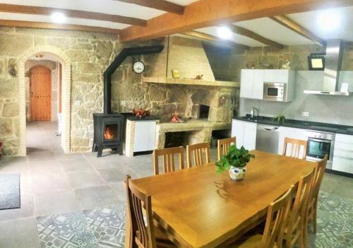 尼格兰Casa Turistica Nigrán的厨房配有木桌和壁炉。