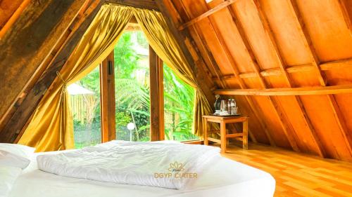 塞亚特New DGYP Ciater Resort的一张位于带大窗户的房间内的床铺