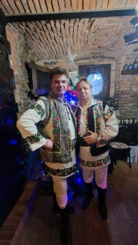 坎普朗莫道尼斯Casa Domnească Rarau的两个人穿着圣诞服装站在一个房间里
