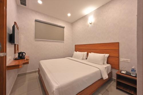 马杜赖CR RIVERA的一间卧室配有一张床和一台平面电视