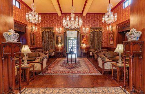 焦特布尔The Ajit Bhawan - A Palace Resort的客厅配有椅子和吊灯。