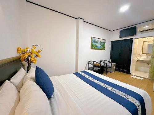 胡志明市New Star Inn Boutique Hotel-Near Bến Thành Market的卧室配有带蓝色枕头的大型白色床