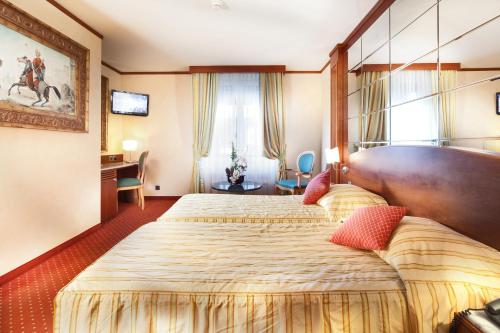日内瓦Hotel Strasbourg的酒店客房设有两张床和窗户。