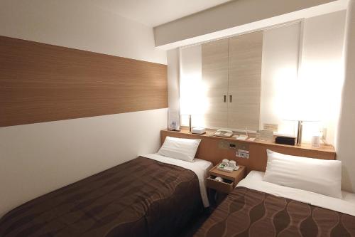 新泻新泻乡村酒店的酒店客房设有两张床和窗户。