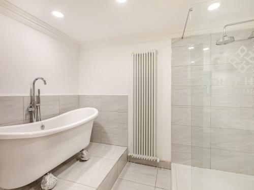 亚姆Iris Apartment - Uk45966的白色的浴室设有浴缸和淋浴。