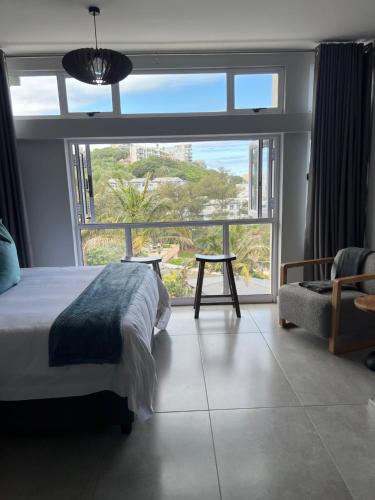 乌姆德洛蒂Beachfront Umdloti Resort 303的一间卧室设有一张床和一个大窗户
