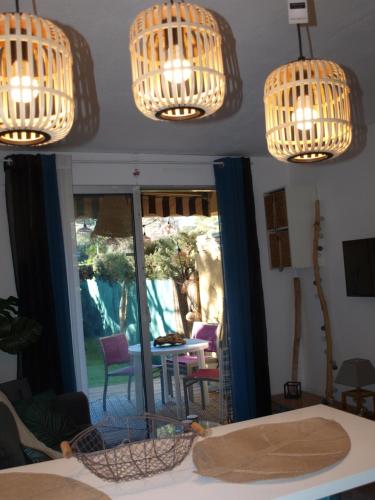 圣拉斐尔Studio le Mistral的客房设有2个吊灯和桌椅