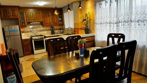 奥塔瓦洛Wasi Golde oro的一间带桌椅的厨房和一间带炉灶的厨房