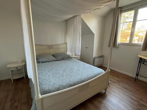 埃尔顿Cottage Duplex golf de Limère prox Orléans的一间卧室配有一张带天蓬的床