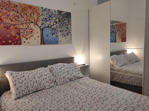 帕尔马KAIROS RESIDENCE的卧室配有一张床,墙上挂着一幅树画