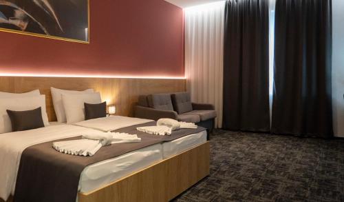莫斯塔尔HA Hotel Mostar的配有一张床和一把椅子的酒店客房