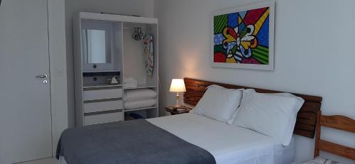 卡波布里奥Flat 404 Hotel Mandai的卧室配有一张床,墙上挂有绘画作品