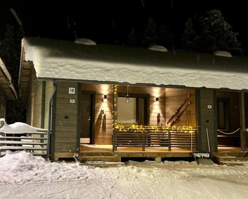 普哈圣山Pyhä Snowflake的一座晚上被雪覆盖的建筑,有灯光