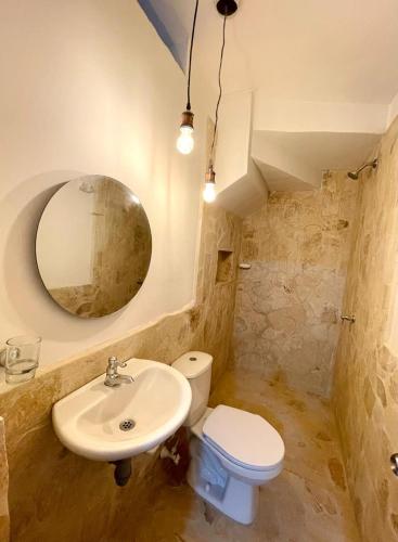 多拉代尔Cabaña Villa Jardín - Aldea Doradal - Santorini Colombiano的一间带水槽、卫生间和镜子的浴室