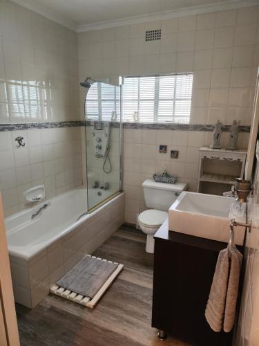 弗莱海德Rosewood Guest Cottage的带浴缸、卫生间和盥洗盆的浴室