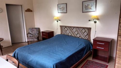 GualeguaychúLo de Tini的一间卧室配有蓝色的床和两张桌子及椅子