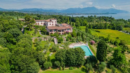 代森扎诺-德尔加达Castello Belvedere Apartments的享有带游泳池的大房子的空中景致