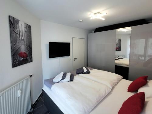 巴特克罗伊茨纳赫Komfortable 2-Zimmer-Ferienwohnung am Kurpark的一间卧室设有一张大床和一台墙上的电视。