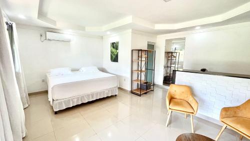 费尔南多 - 迪诺罗尼亚Terras Verdes Residence的白色卧室配有床和椅子
