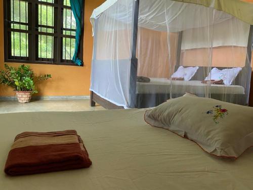 蒂瑟默哈拉默Yala Ying Yang Hostel & Camping的卧室内的一张大床,设有天篷