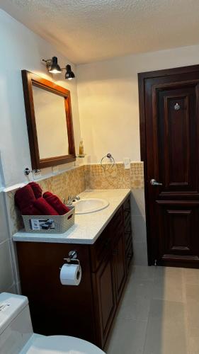 奥塔瓦洛Wasi Golde oro的一间带水槽、镜子和卫生间的浴室