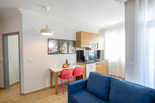 阿拉尼亚Comfort Suites的一间带蓝色沙发的客厅和一间厨房