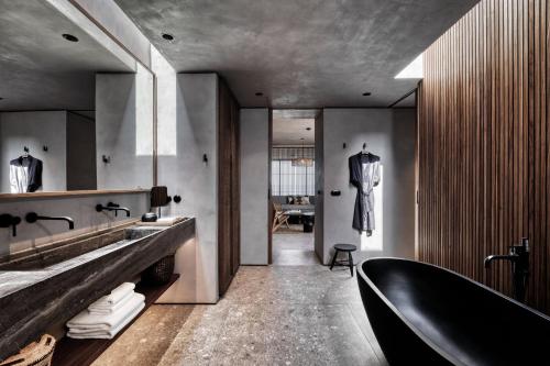 加藤-达拉特索Domes Zeen Chania, a Luxury Collection Resort, Crete的浴室配有黑色浴缸和水槽