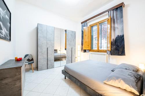 佛罗伦萨Camera 'Dolphin' - eleganza e tranquillità的一间卧室配有一张床、一张书桌和一个窗户。