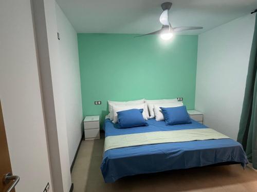 科蒂略Casa Teri - Los Lagos的一间卧室拥有蓝色的墙壁,配有一张带蓝色枕头的床。