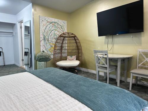 洛杉矶Foghorn Harbor Inn的一间卧室配有一张床、一张书桌和一台电视。