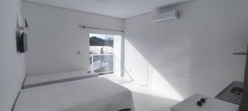 弗洛里亚诺波利斯Recanto do Valtinho的白色的卧室设有床和窗户