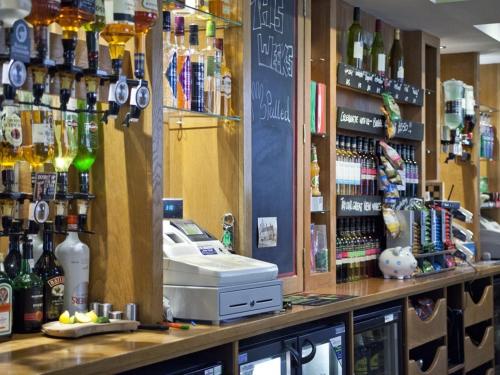 约克Burton Stone Inn - Free Parking on site的酒吧提供现金寄存处和瓶装酒精饮品