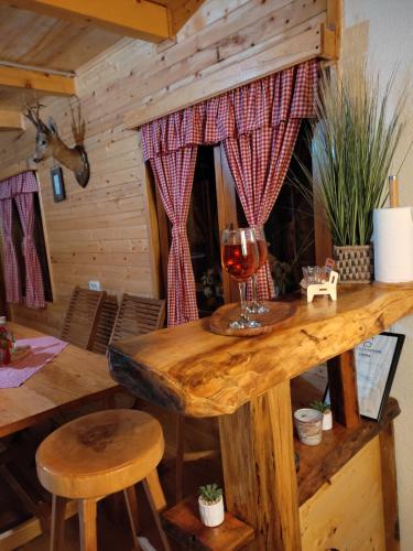戈斯皮奇Kuća za odmor Antonija的一张木桌,上面放着一杯葡萄酒