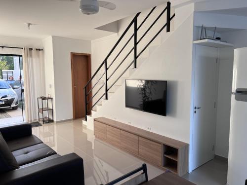 南圣弗朗西斯科Brisas de São Chico - 450m da Praia的客厅配有沙发和墙上的电视