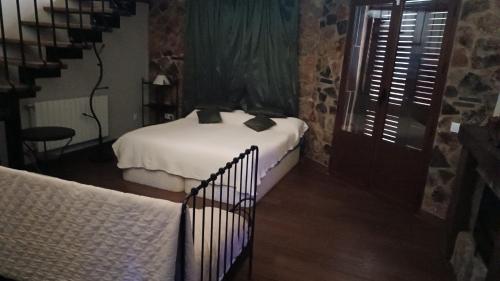 La Codosera卡米诺德尔阿连特茹农家乐的一间带两张床的卧室,位于一个设有楼梯的房间