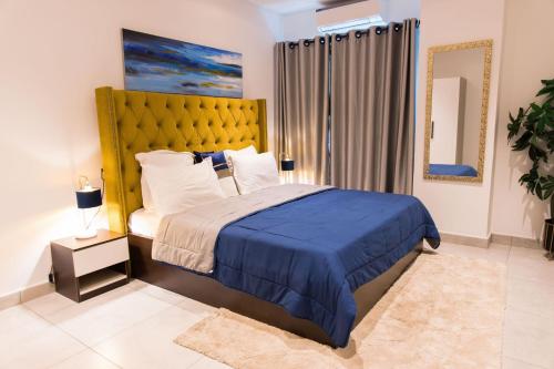 阿克拉Luxury 2 Bedroom Apartment East Legon - Accra的一间卧室配有一张带黄色床头板的大床