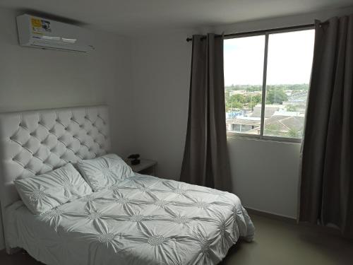 里奥阿查Hermoso apartamento frente al mar的一间卧室设有一张床和一个大窗户